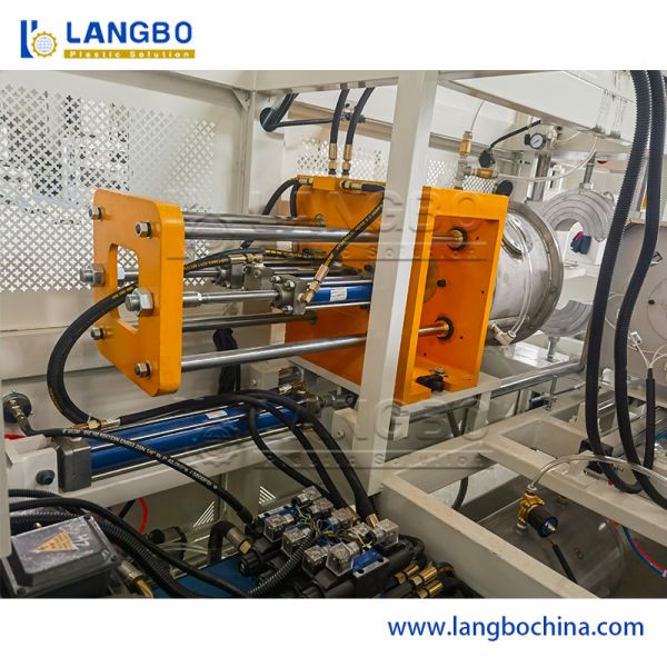 Side view of automatic pipe belling machine showing horizontal pipe movement system
